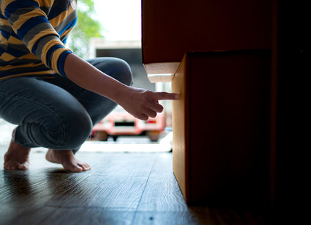 Asian woman checking boxes being transported into new homeの写真素材