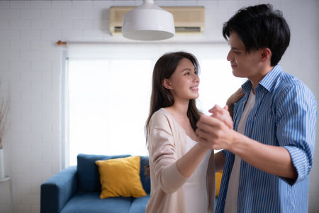 A couple dancing together in the living room of the house.の写真素材