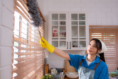 Asian young woman cleaning window in the kitchen. housework concept