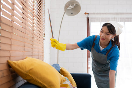 Young women cleaning maid in uniform are cleaning the living room at home.の写真素材