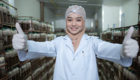 Portrait of young asian muslim female scientist doing research at a mushroom factory, examining...