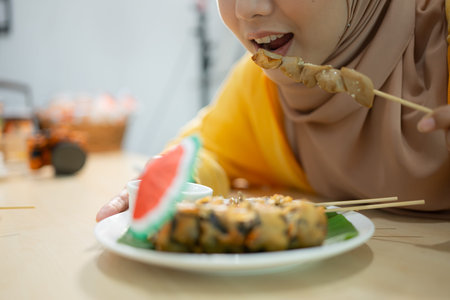 Muslim girl eating mushroom sushi at the restaurant. Selective focus on sushi