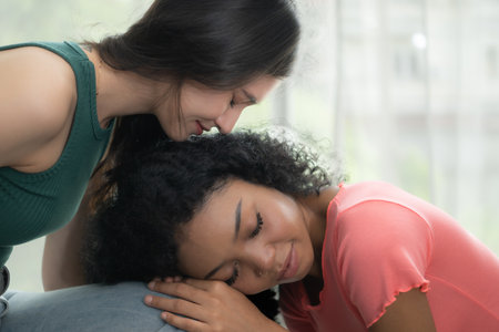 Portrait of a young woman consoling her sad friend at homeの写真素材