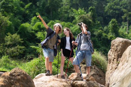 Group of tourists with backpacks walking on the trail in the river and mountainsの写真素材