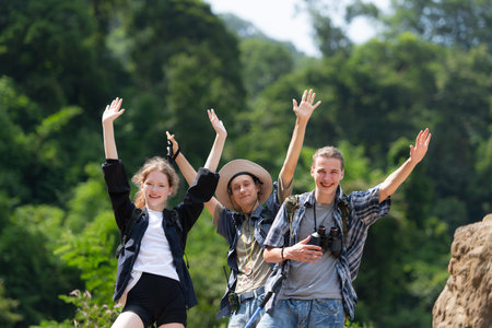 Group of tourists with backpacks walking on the trail in the river and mountainsの写真素材