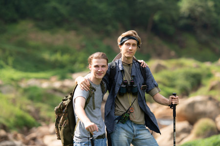 Two man hiking in the forest with backpacks and trekking polesの写真素材