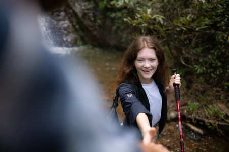 Young couple of hikers sitting on a rock and looking at each otherの写真素材
