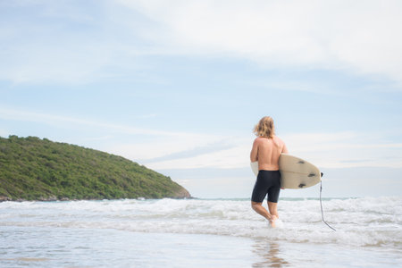 Surfer man with his surfboard on the beach.の写真素材
