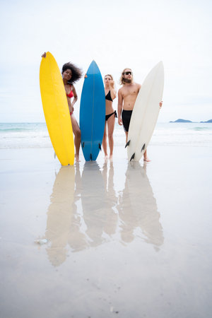 Portrait of smiling young woman in bikini with surfboard at beach