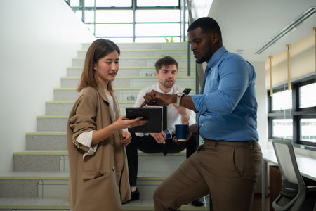 Group of businessperson using digital tablet while standing on stairs in office building