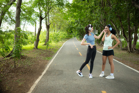 Portrait of two young women jogging in the park and smilingの写真素材