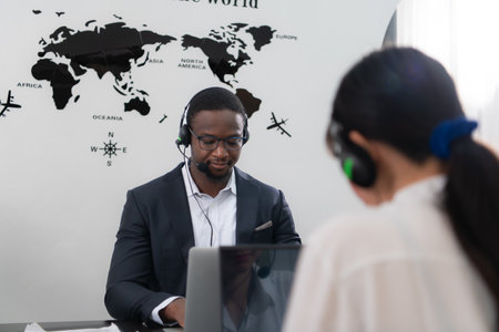 Portrait of business people wearing headset working actively in office. Call center, telemarketing, customer support agent provide service on telephone video conference call.の写真素材
