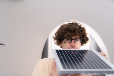 A young male architect and designer is designing a green home building that takes advantage of...