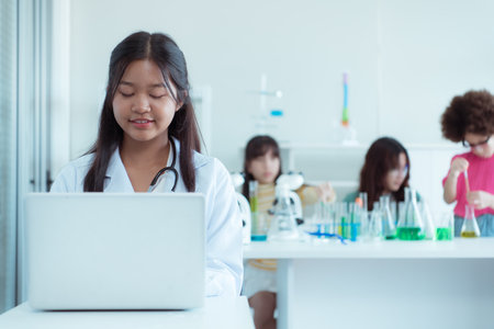 In the science classroom, an Asian child scientist experimenting with scientific formulas with chemicalsの写真素材