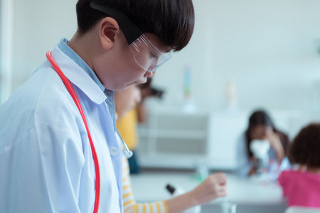 In the science classroom, an Asian child scientist experimenting with scientific formulas with chemicalsの写真素材