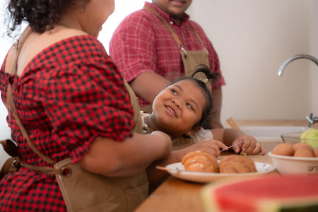 A plus-size family with a father wearing a prosthetic leg, They happily make breakfast together in the in the kitchen room of the houseの写真素材