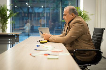 Senior businessman working with documents and Mature businessman working on laptop computer in...