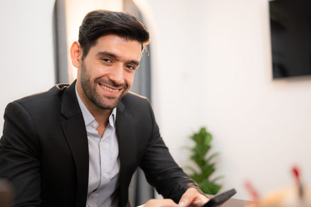 Portrait of a handsome young businessman using smartphone in office.
