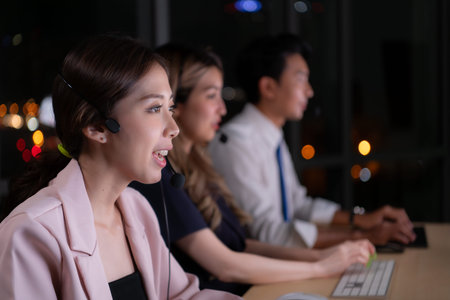 Group of broker international stock traders wearing headset working actively at night in office,...