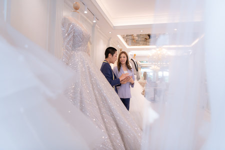 Both of asian fashion designers working with wedding dress in the wedding dress shopの写真素材
