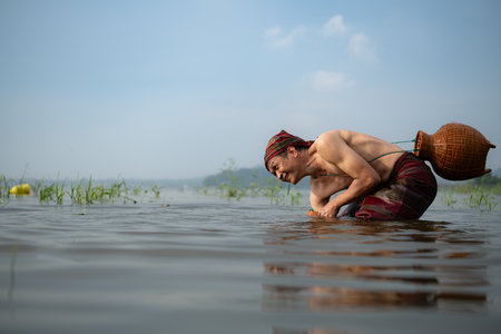 Fisherman using traditional fishing gear to catch fish for cooking, Rural Thailand living life conceptの写真素材