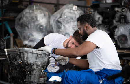 Two men repairing car engine in auto repair shop, Selective focus.の写真素材
