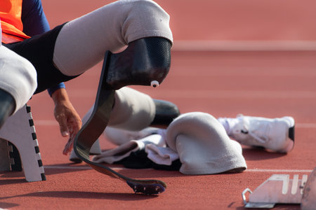 Disabled athletes prepare in starting position ready to run on stadium trackの写真素材