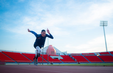 Disabled athletes prepare in starting position ready to run on stadium trackの写真素材
