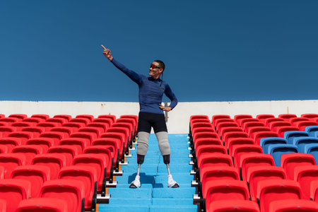 Athletes with disabilities cheer from the stands in a sports arena.の写真素材