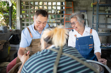Portrait of a senior Asian couple doing activities together in the pottery workshop.