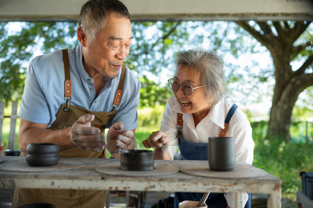 Portrait of a senior Asian couple doing activities together in the pottery workshop.の写真素材
