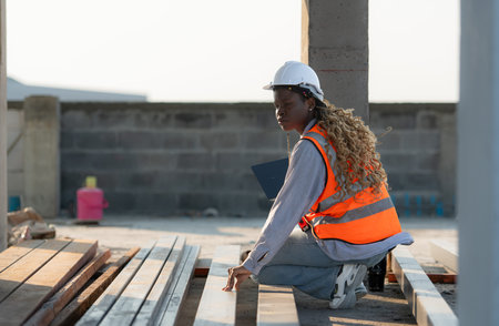 Young female architect working on a construction site with a laptop in her handsの写真素材