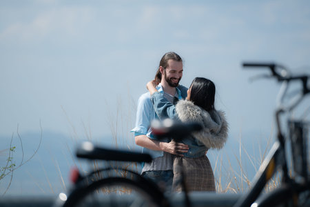 Young couple in love on the top of the mountain with bicycle foregroundの写真素材