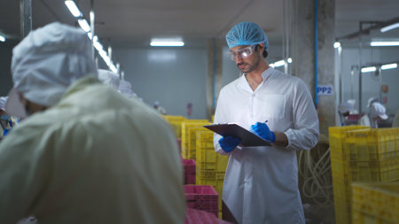 Production control supervisor inspects and controls the operation of each step in the production line of a canned fish factoryの写真素材