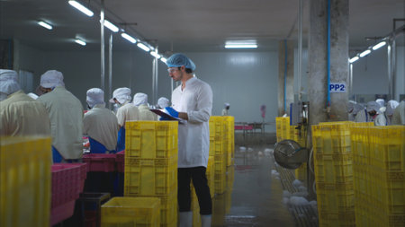 Production control supervisor inspects and controls the operation of each step in the production line of a canned fish factoryの写真素材