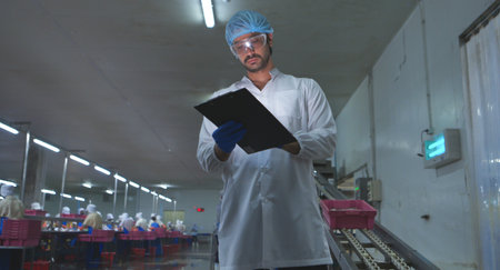 Production control supervisor inspects and controls the operation of each step in the production line of a canned fish factoryの写真素材