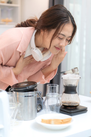 Asian young woman enjoying bread and coffee for breakfast at home, morning routine before workの写真素材
