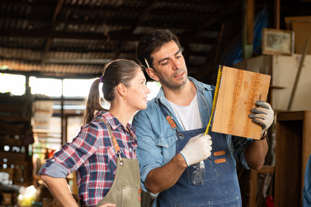 Carpenter and his assistant working together in a carpentry workshopの写真素材
