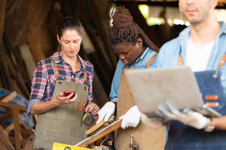 Portrait of carpenter male worker standing with laptop in workshopの写真素材