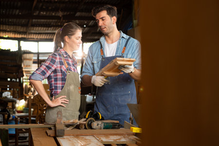 Carpenter and his assistant working together in a carpentry workshopの写真素材