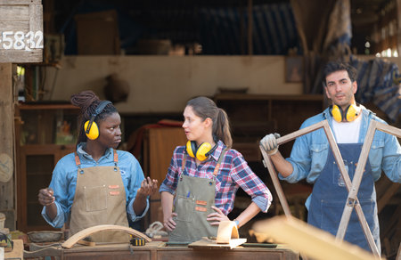 Carpenter and his assistant working together in a carpentry workshopの写真素材