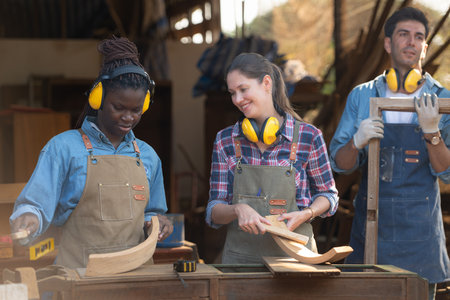 Carpenter and his assistant working together in a carpentry workshopの写真素材