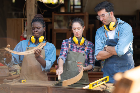 Carpenter and his assistant working together in a carpentry workshopの写真素材
