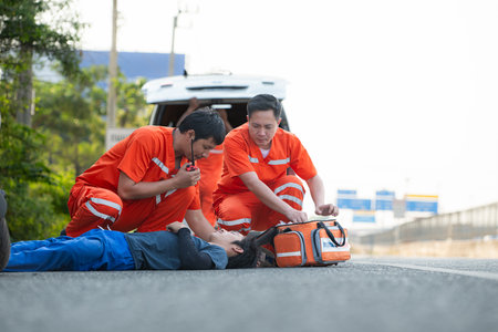 The paramedic  is assisting an injured man in an emergency situation on the road.の写真素材