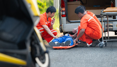 The paramedic  is assisting an injured man in an emergency situation on the road.の写真素材