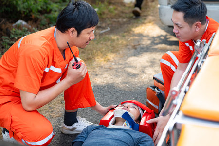 The paramedic  is assisting an injured man in an emergency situation on the road.の写真素材