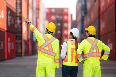 Group of engineers working with laptop in the container yard. This is a freight transportation and distribution warehouse.の写真素材