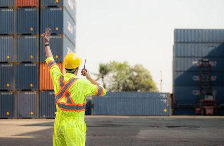 Workers in the import and export industry use walkie talkies to communicate with drivers of reach...
