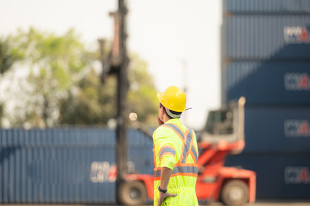Workers in the import and export industry use walkie talkies to communicate with drivers of reach...