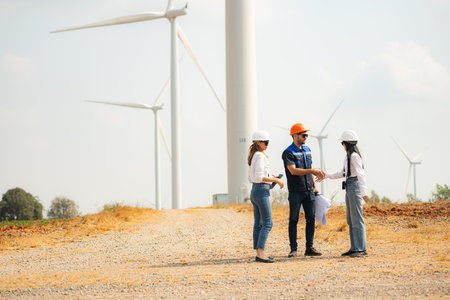 Team of engineers and architects working on wind turbines in a wind farmの写真素材